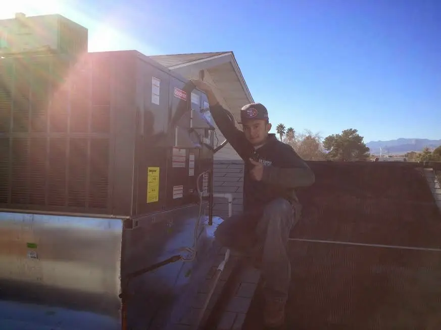 HVAC technician performing Boiler Repair on a rooftop unit in College